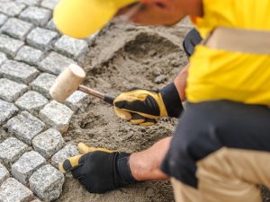 Professional Construction Worker Laying Pavers